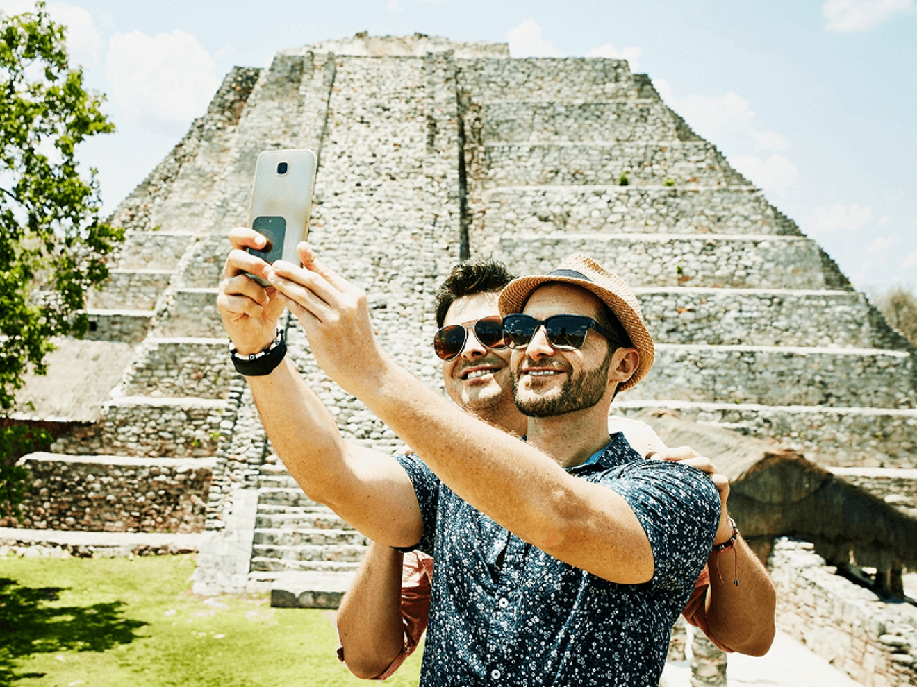 Two people take a selfie near an ancient ruin.